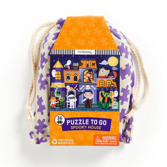 The Liv Wan Spooky House 36 Piece Puzzle to Go comes in a drawstring bag with a label featuring a cartoon haunted house, costumed characters, and purple puzzle piece designs.