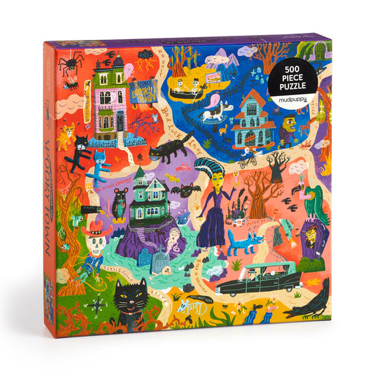 The Welcome to Spooky Town 500 Piece Family Puzzle by Stephanie Birdsong features a vibrant, whimsical Halloween scene with haunted houses, witches, black cats, and skeletons—perfect for family fun.