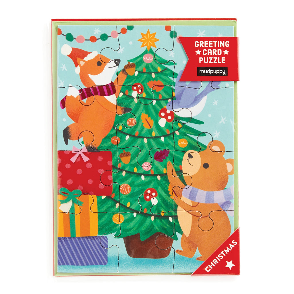 The Christmas Critters Greeting Card Puzzle by Ana Peake features a fox and bear decorating a tree. Festive lights and presents create holiday charm—ideal for entertainment and spreading cheer this season.