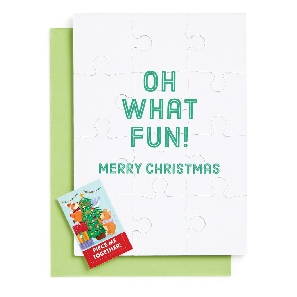 The Ana Peake Christmas Critters Greeting Card Puzzle features reindeer and a tree, green OH WHAT FUN! MERRY CHRISTMAS text, comes with a light green envelope, plus a festive PIECE ME TOGETHER! label.