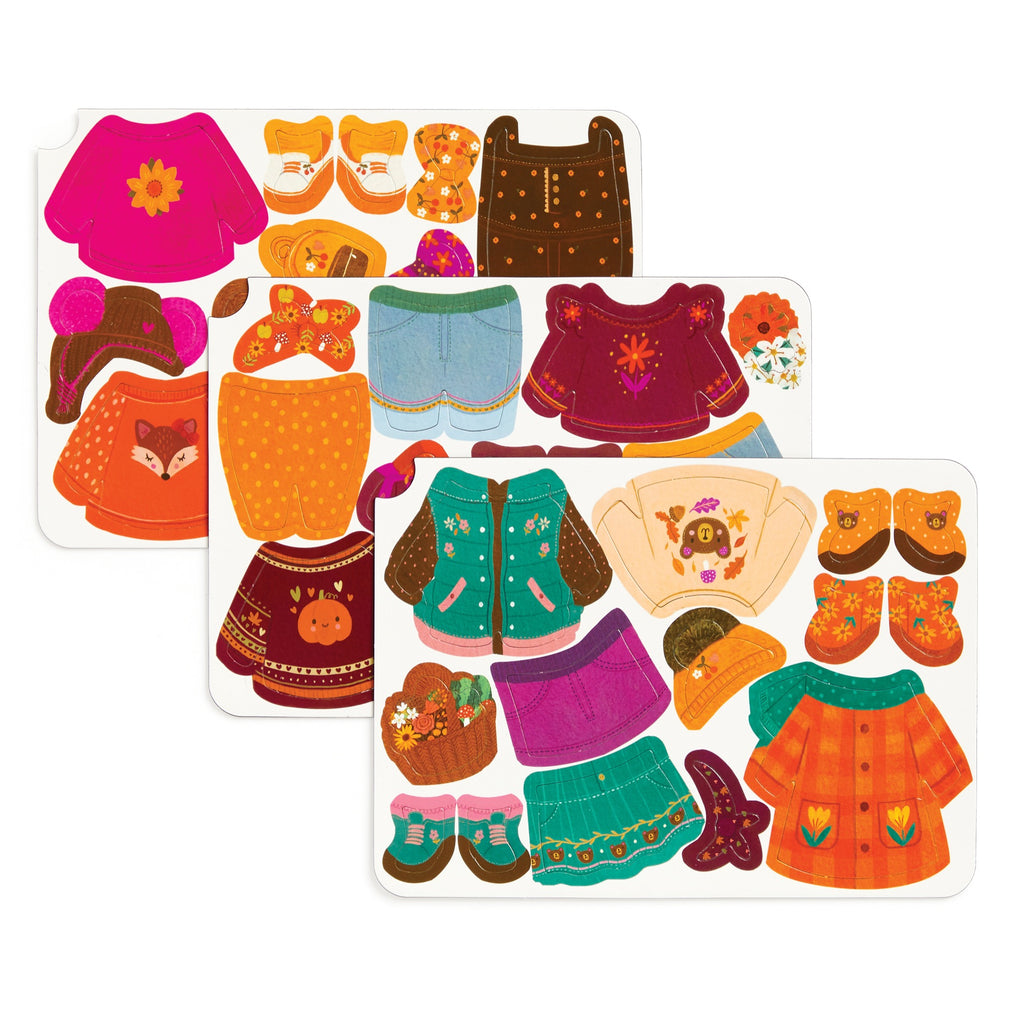 The Folklore Forest Magnetic Dress-up Play Set by Jenny Miriam Hughes features three illustrated sheets of colorful cut-out clothing and fairy tale accessories—hats, purses, boots—in orange, pink, blue, and green with animal and floral designs.