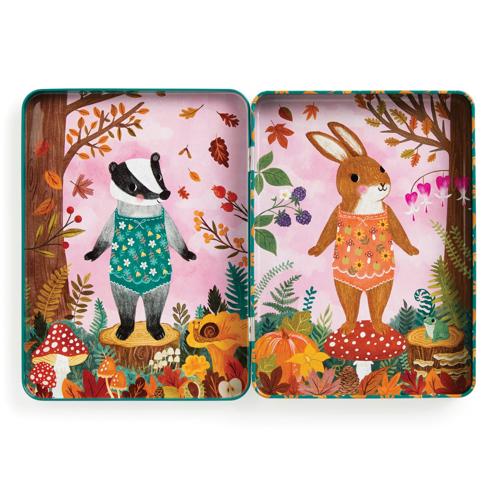 In the Jenny Miriam Hughes Folklore Forest Magnetic Dress-up Play Set, a badger in blue overalls and a rabbit in orange stand among mushrooms, flowers, and leaves—ready for fairy tale fun with magnetic accessories.