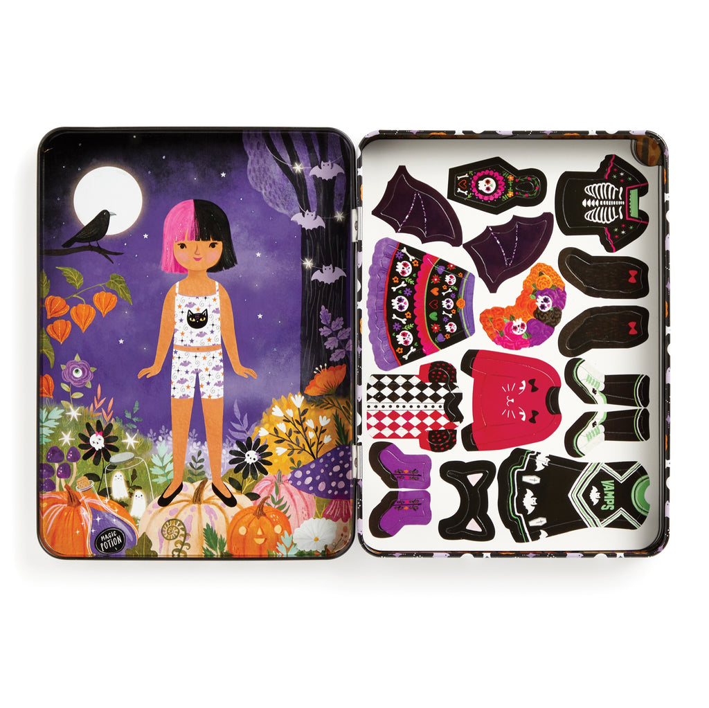 The Jenny Miriam Hughes Spooky Season Magnetic Dress-up Play Set comes in a tin box featuring a girl with pink and black hair in pajamas and includes magnetic costume pieces—wings, sweaters, dresses—for creative Halloween play.