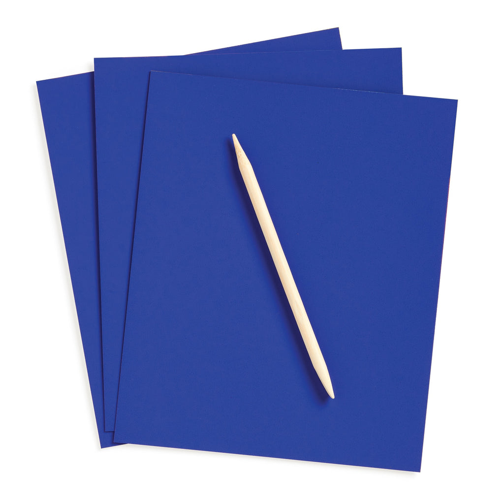 Three sheets of Katie Woods Cosmic Galaxy Scratch Magic paper are stacked askew, with a wooden stylus laid diagonally across the top sheet, inviting kids to create their own cosmic scenes.