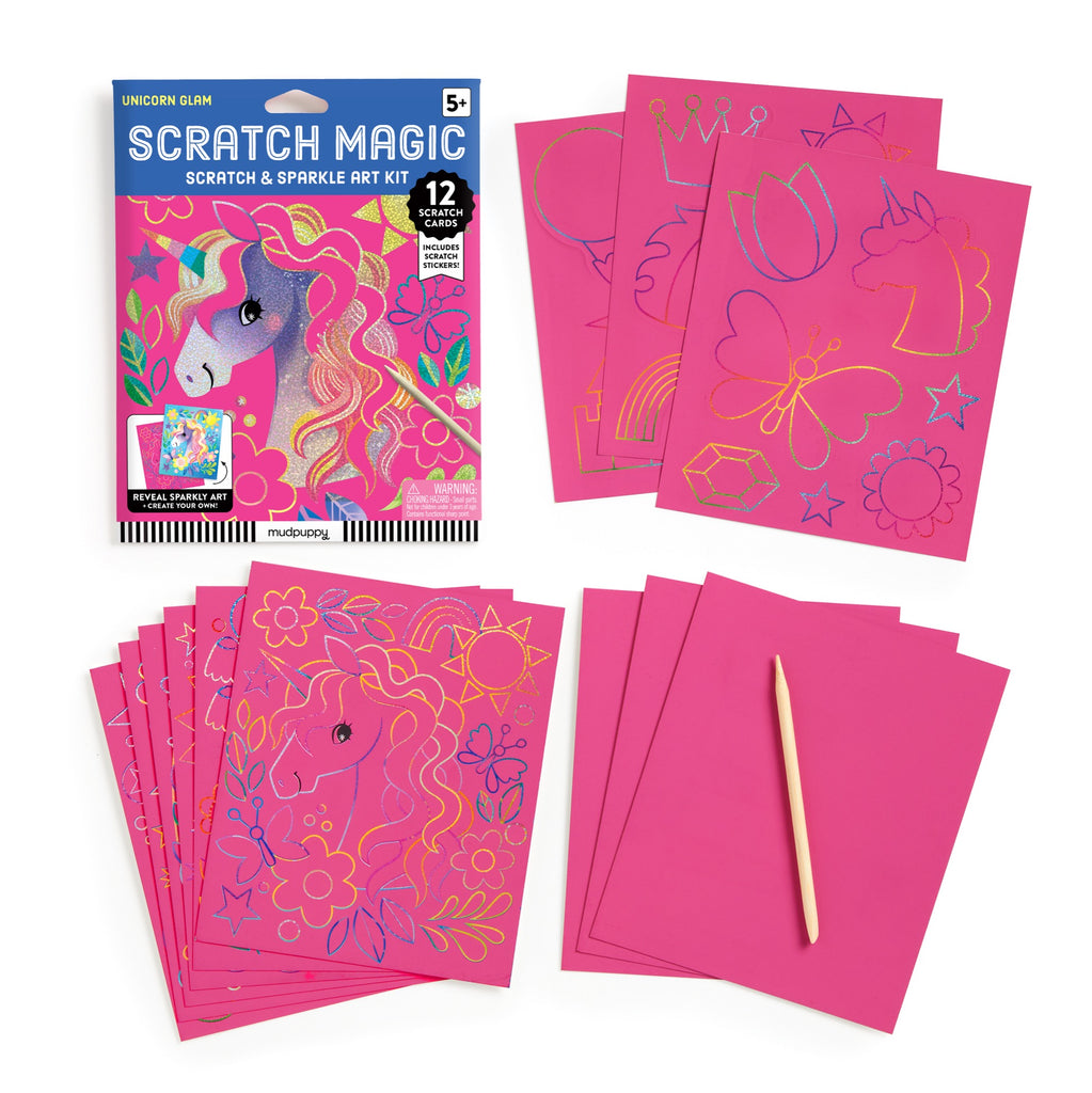 The Katie Wood Unicorn Glam Scratch Magic kit includes a colorful box, pink scratch cards with unicorn and magic designs, unicorn stickers, and a wooden stylus. Ideal creative fun for ages 5 and up.