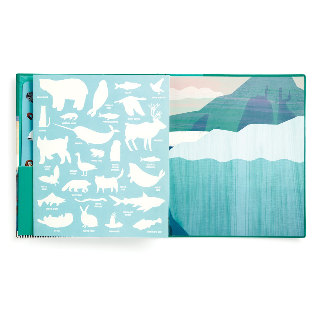 An open book from the Hannah Abbo Arctic Life Sticker Play Reusable Activity Set shows white Arctic animal silhouettes with labels on a blue page, next to an illustrated iceberg and mountains beneath a soft pastel sky.