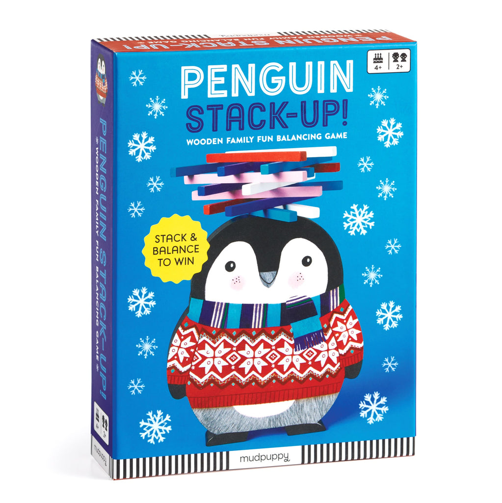 The image features a blue box for the Rebecca Jones Penguin Stack-up Wooden Balancing Game, showing a penguin in a red sweater balancing colorful planks amid snowflakes. The tagline reads: Stack & balance to win—great for fine motor skills.