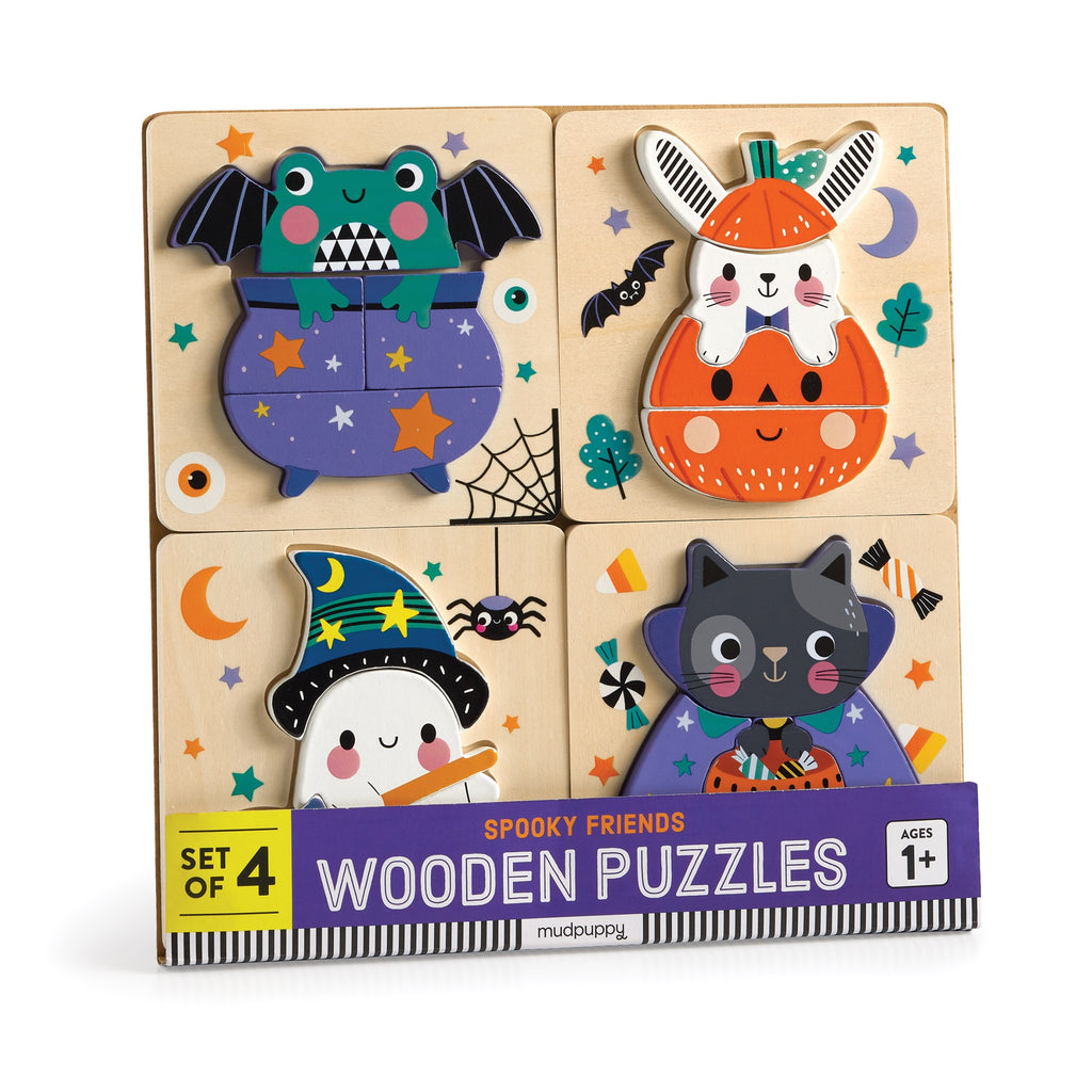 The Wendy Kendall Spooky Friends Set of 4 Wood Puzzles features a bat-winged frog, pumpkin bunny, ghost in witch hat, and black cat with candy. Made from durable wood and suitable for ages 1+.
