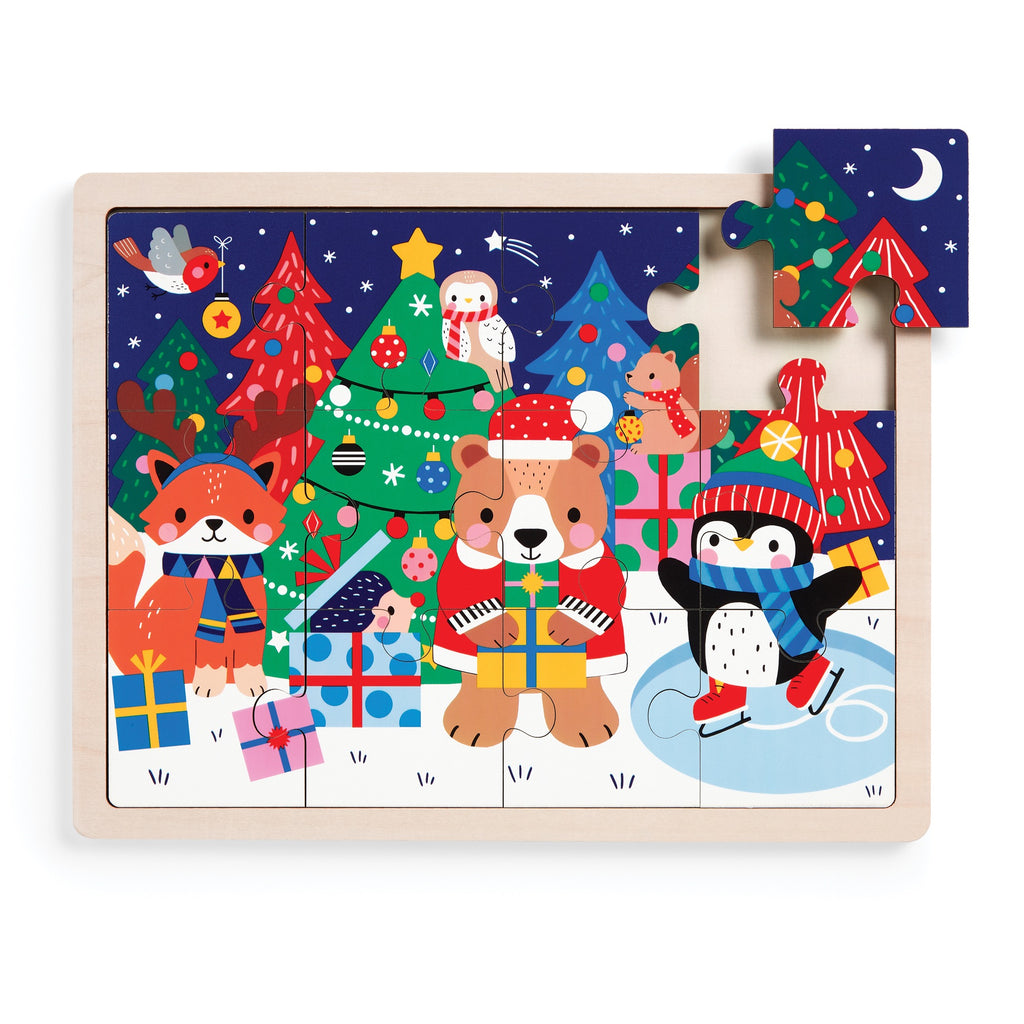 The Wendy Kendall Festive Friends 12 Piece Wooden Tray Puzzle features holiday characters, Christmas trees, presents, and snow, with a moon-and-stars wooden piece ready to be placed in the top right corner.