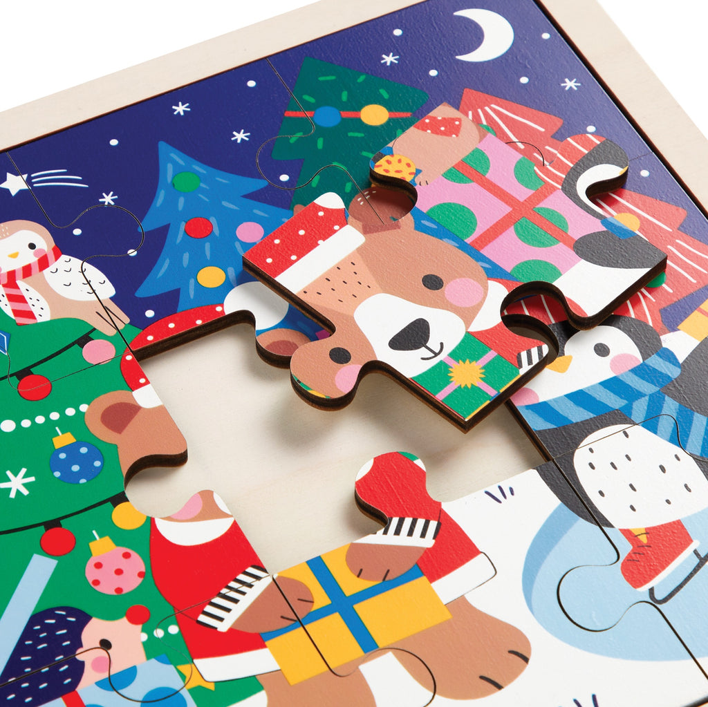 The Wendy Kendall Festive Friends 12 Piece Wooden Tray Puzzle features vibrant holiday scenes with a bear in a Santa hat, penguin, presents, and a decorated tree beneath a crescent moon.