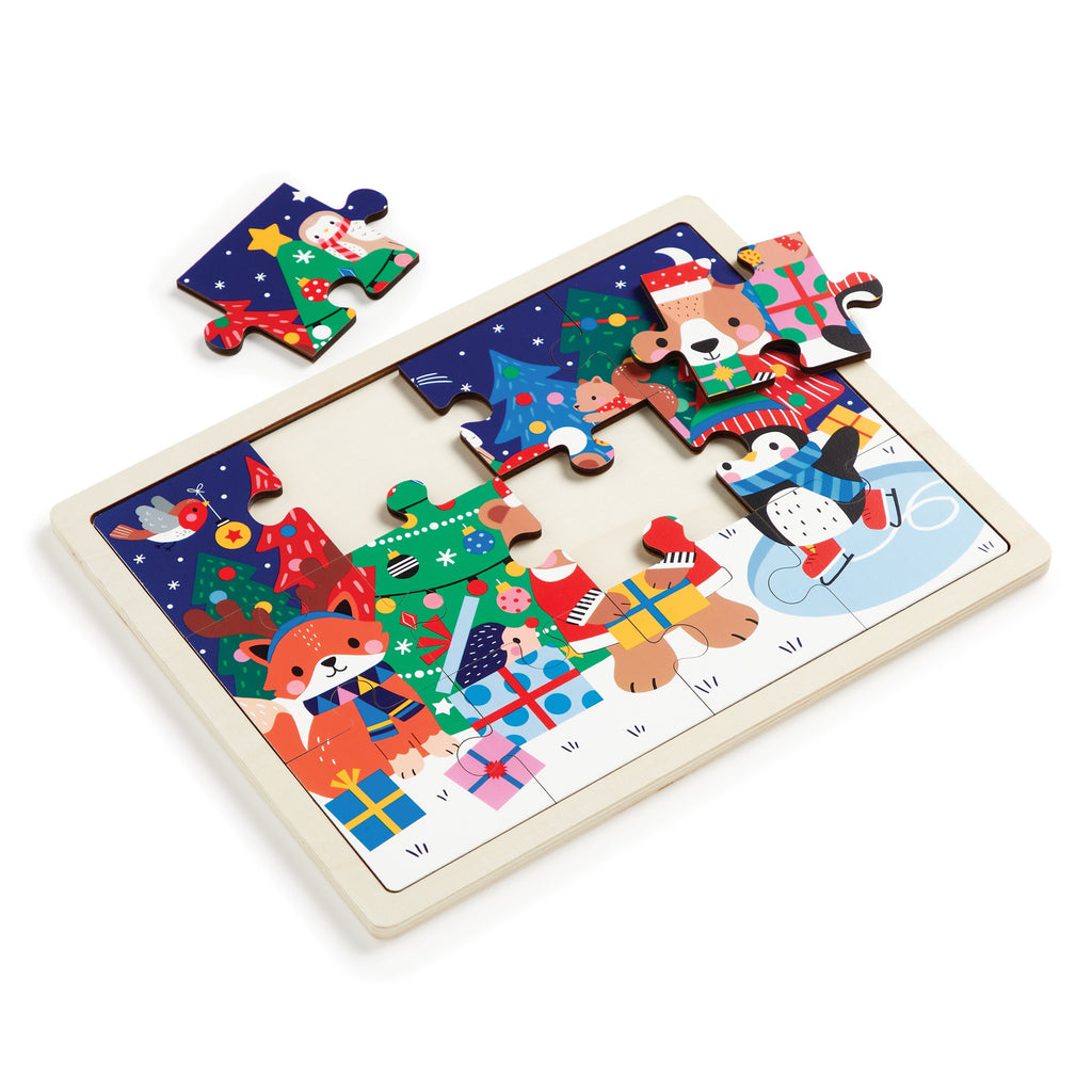 The Wendy Kendall Festive Friends 12 Piece Wooden Tray Puzzle features holiday animals like a fox, bear, penguin, and bunny in winter outfits with decorations. Some pieces are assembled; two pieces sit outside the wooden tray frame.